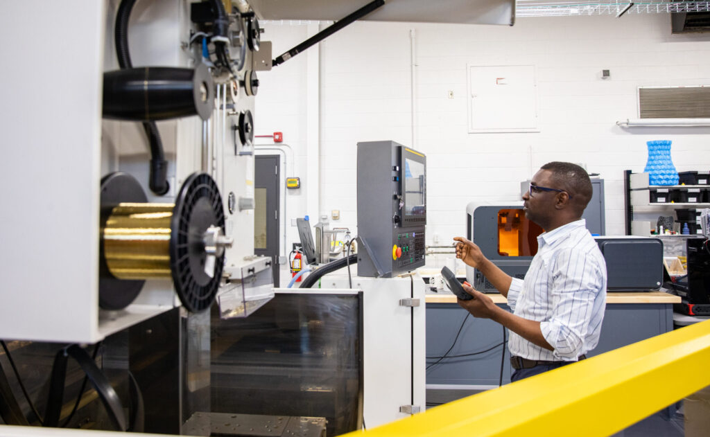 Male researcher working on equipment in RRC Polytech's Technology Access Centre for Aerospace & Manufacturing (TACAM).