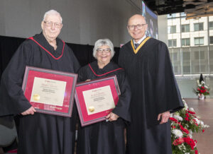 RRC Polytech president Fred Meier presents Don and Joyce Sobering with framed honorary certificates at 2026 convocation ceremony.