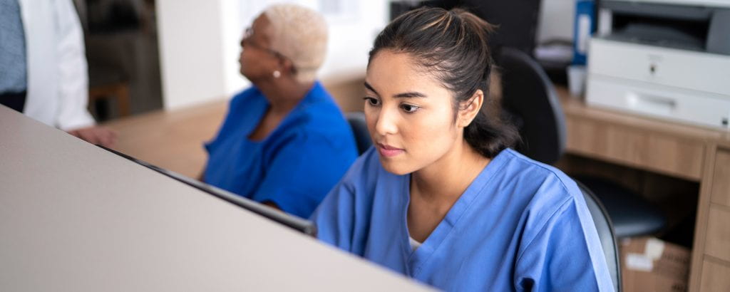 Healthcare program worker at a computer