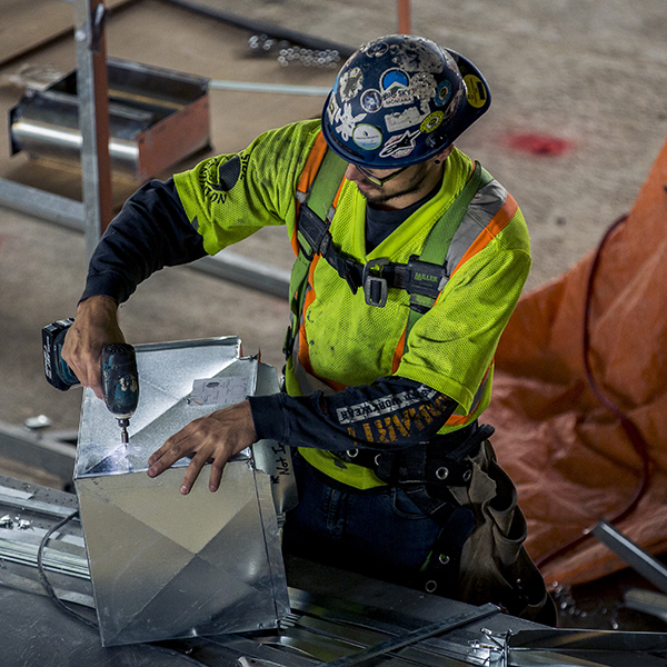 Worker using a power tool at a construction site