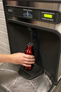 A water bottle being filled at a water bottle filling station.