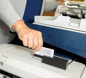 Person swiping their staff card to log into a printer