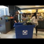 A few students do an audit of a recycling bin on campus.