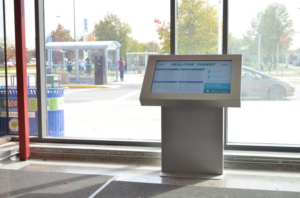 Indoor screen by the bus loop at NDC showing Real-Time Transit updates