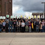 40 RRC Polytech Students and staff standing on the stairs leading from the bus loop to building C at NDC holding a sign that says #climatestrikeRRC