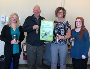 Portage Campus Staff with the Seasonal Shutdown Office Challenge poster at their catered coffee break.