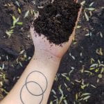 hand holding finished compost that resembles rich black soil