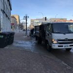 White compost truck pulls up to PGI loading dock to collect 4 compost bins