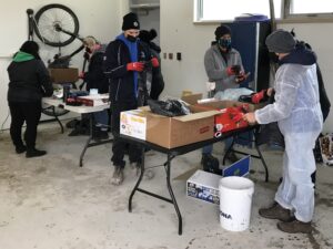 Several students sorting garbage and recycling into categories.