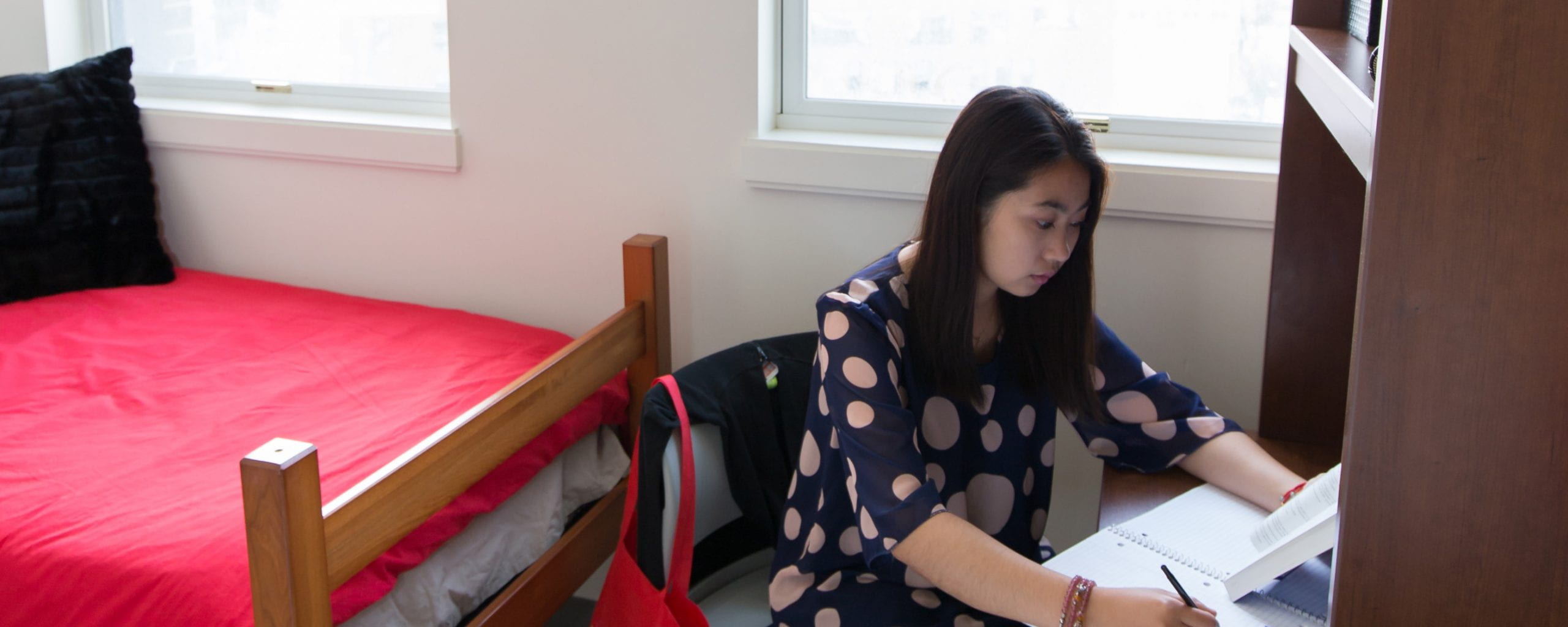 A woman completes paperwork at her home desk