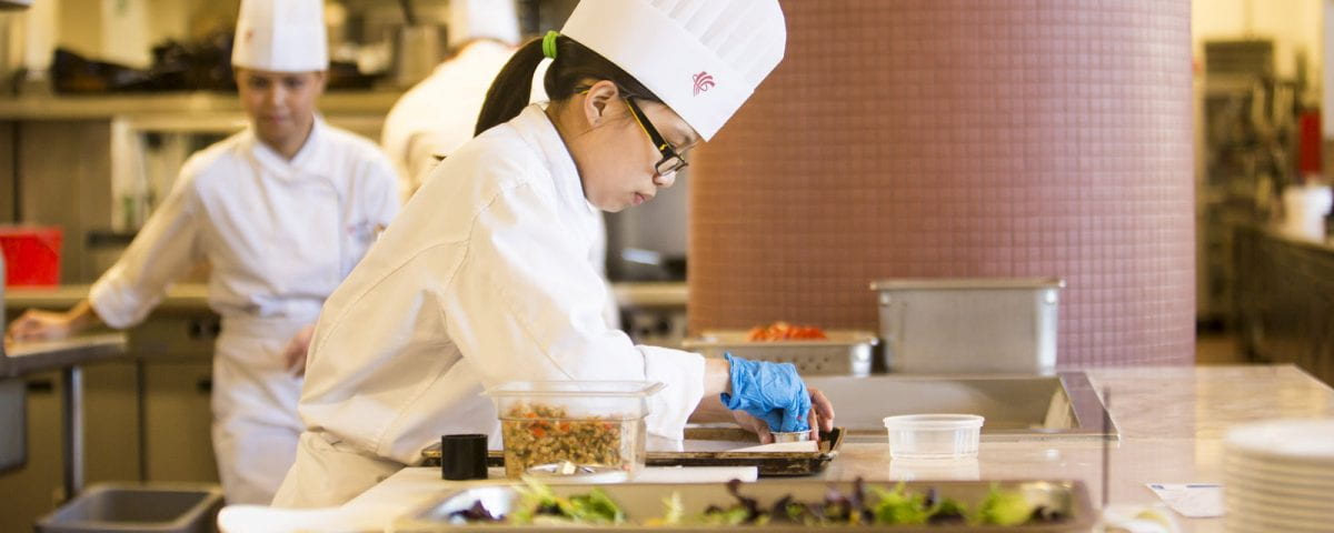 A culinary student prepares a meal