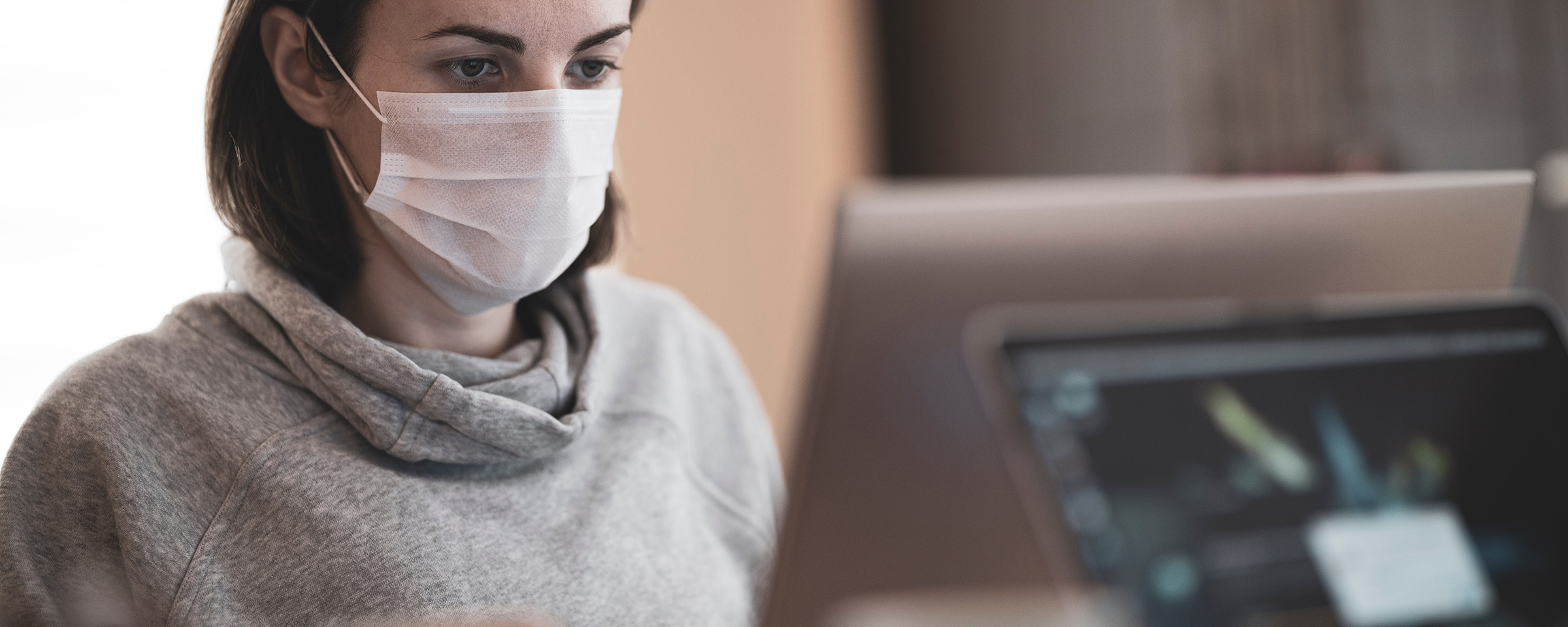 woman wearing mask at a computer