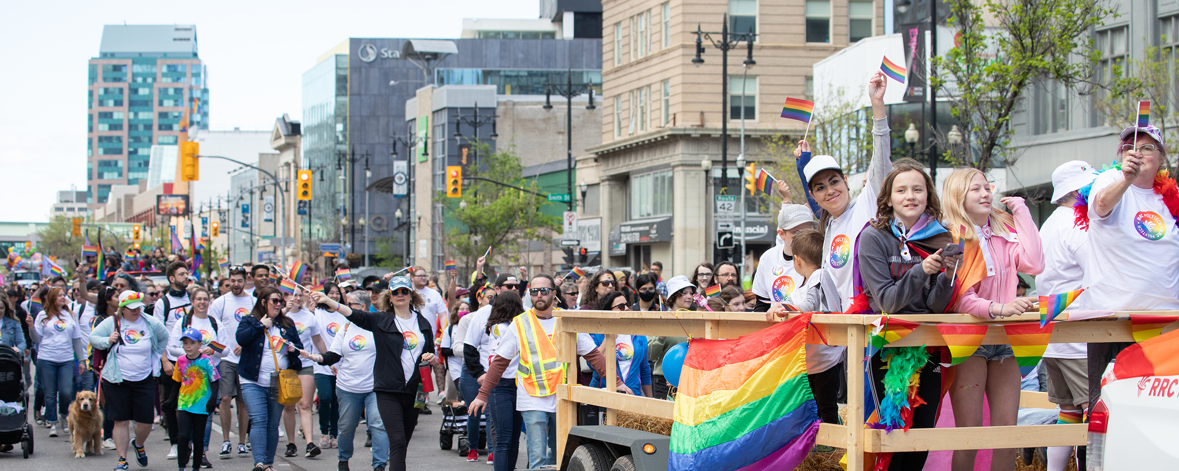 Folx walking in the Pride Winnipeg Parade down Portage Avenue