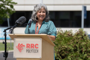 Woman speaking at a podium outdoors