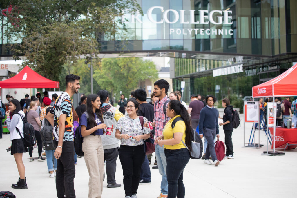 A group of students outside the Exchange District at Red River College Polytechnic interacting with one another. 