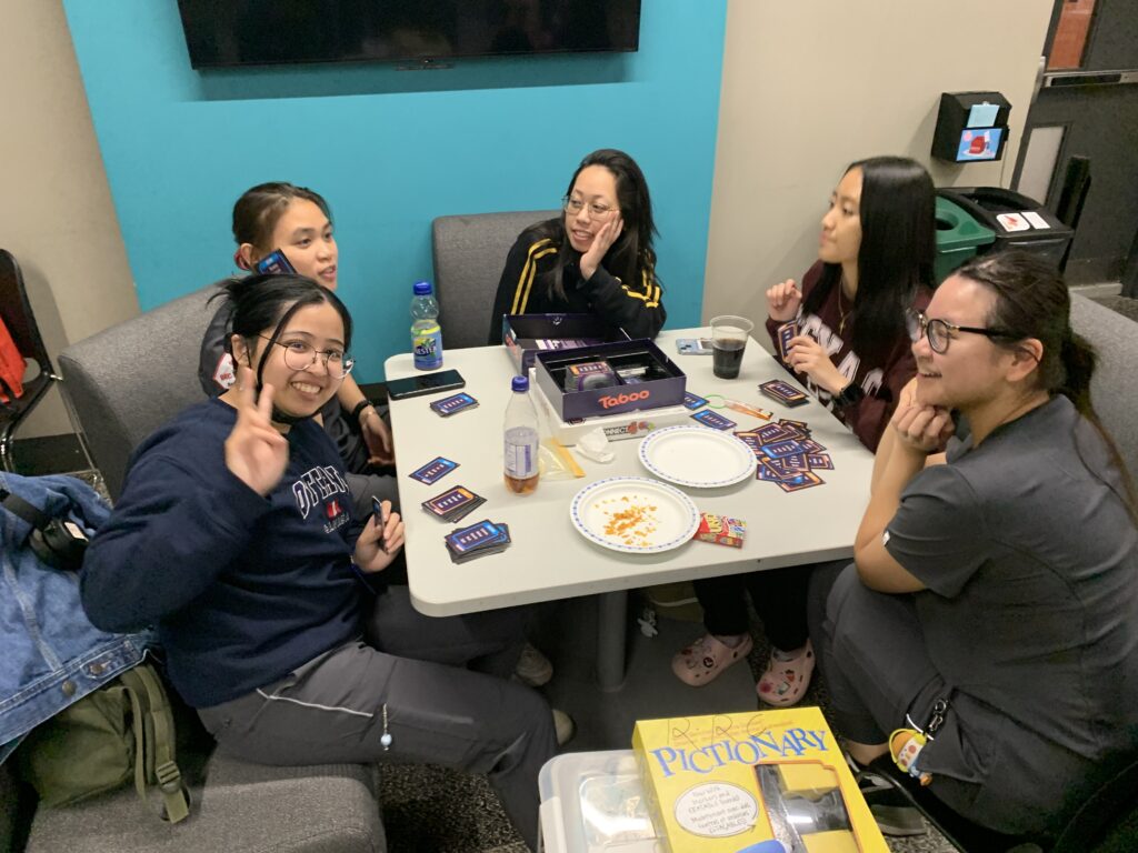 Group of college students playing taboo around a table