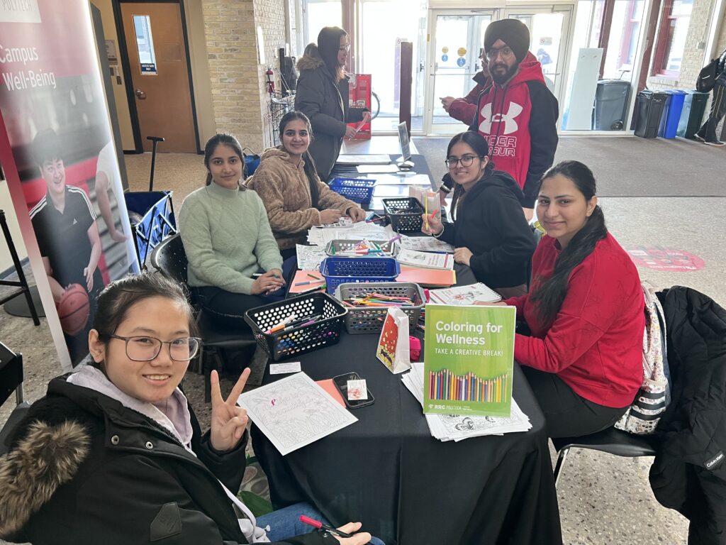 Group of students around a table colouring.