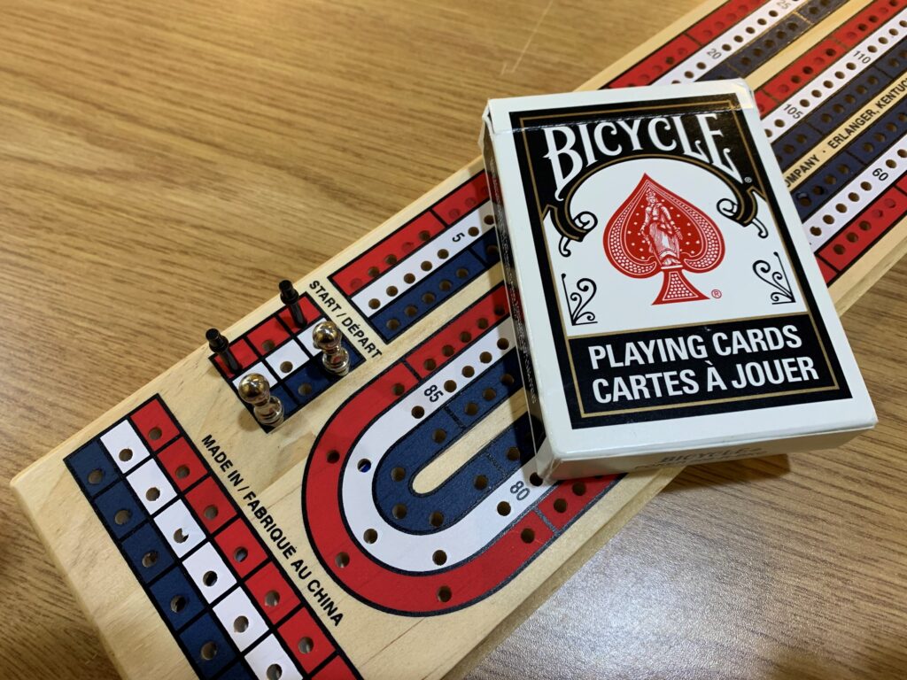 Cribbage board and deck of cards on top.