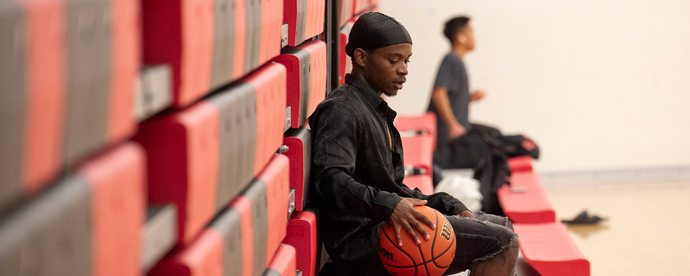 Man sitting on bench with basketball