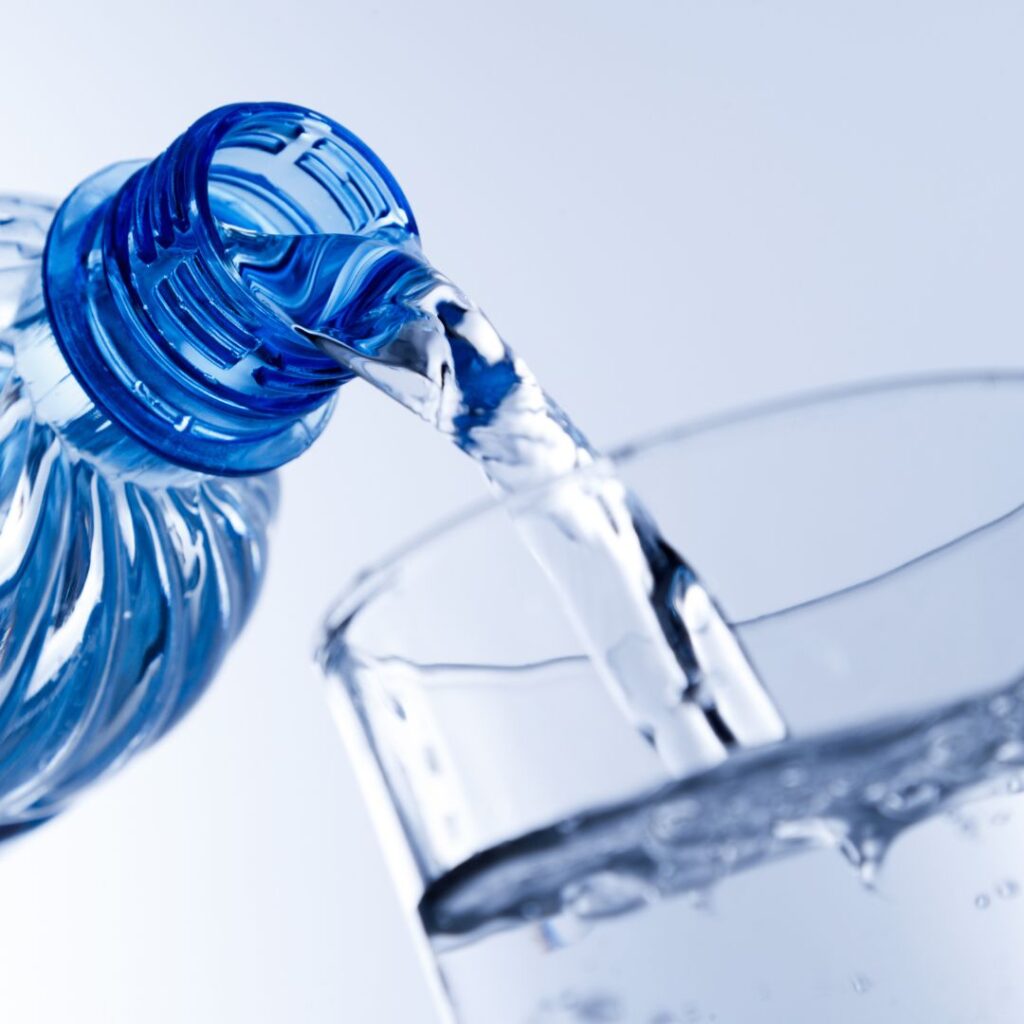 Water bottle filling a glass with water