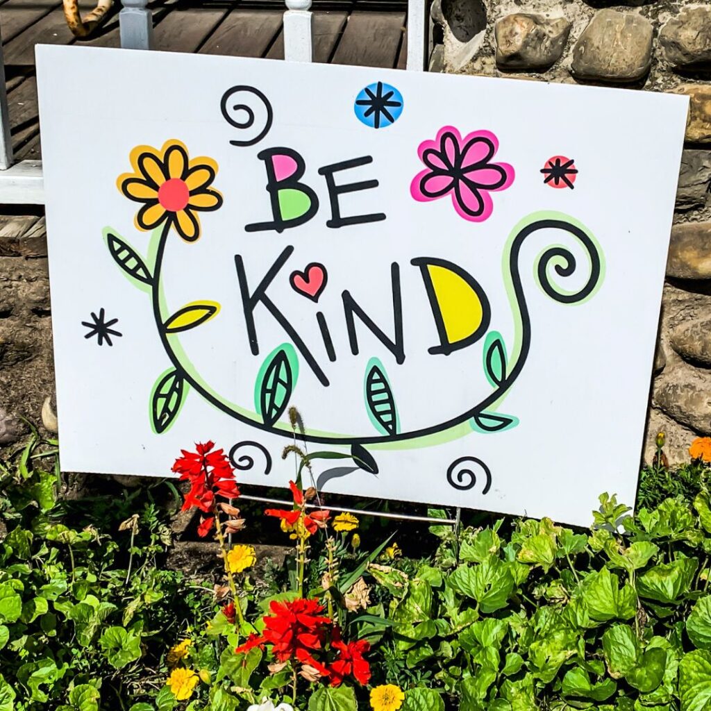 Colourful sign in a garden that says "Be Kind"