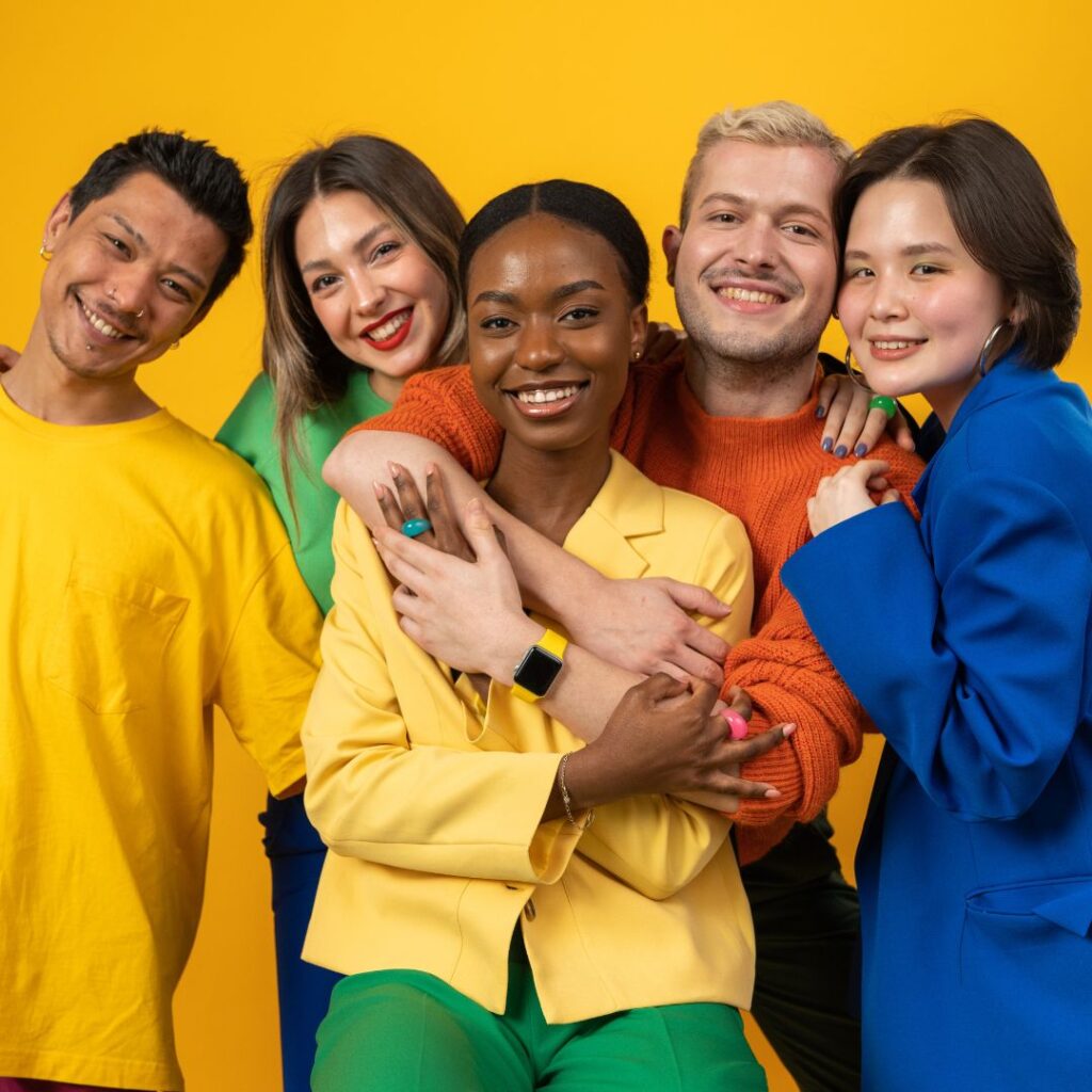 Group of five diverse people wearing vibrant coloured clothing.