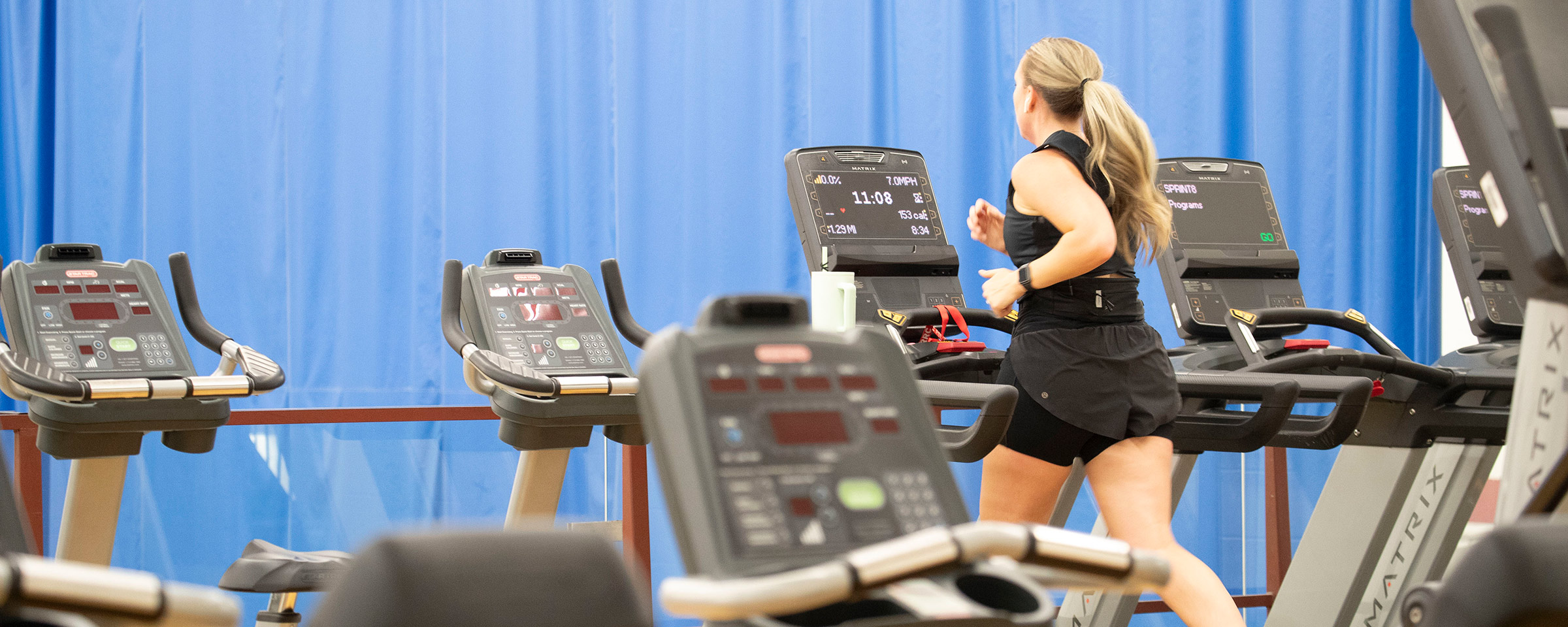 Woman running on a treadmill in a gym