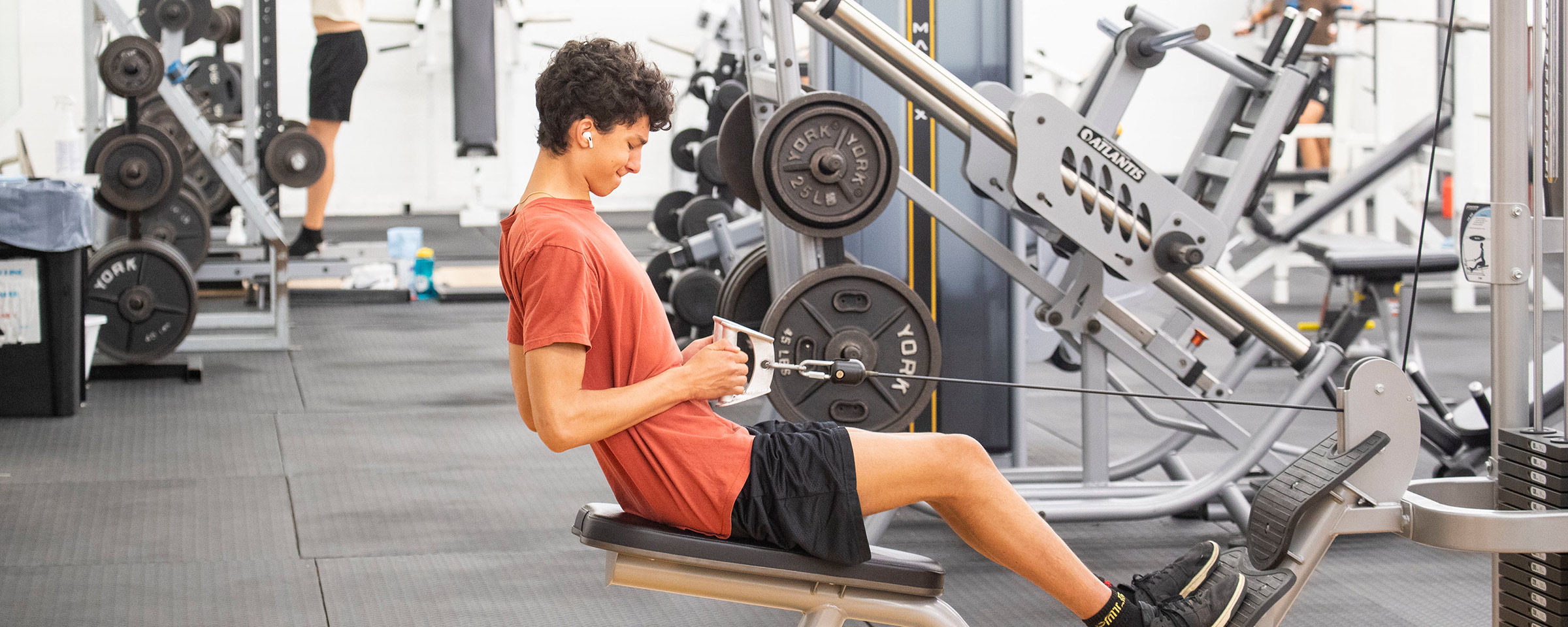 Student lifting weights in gym