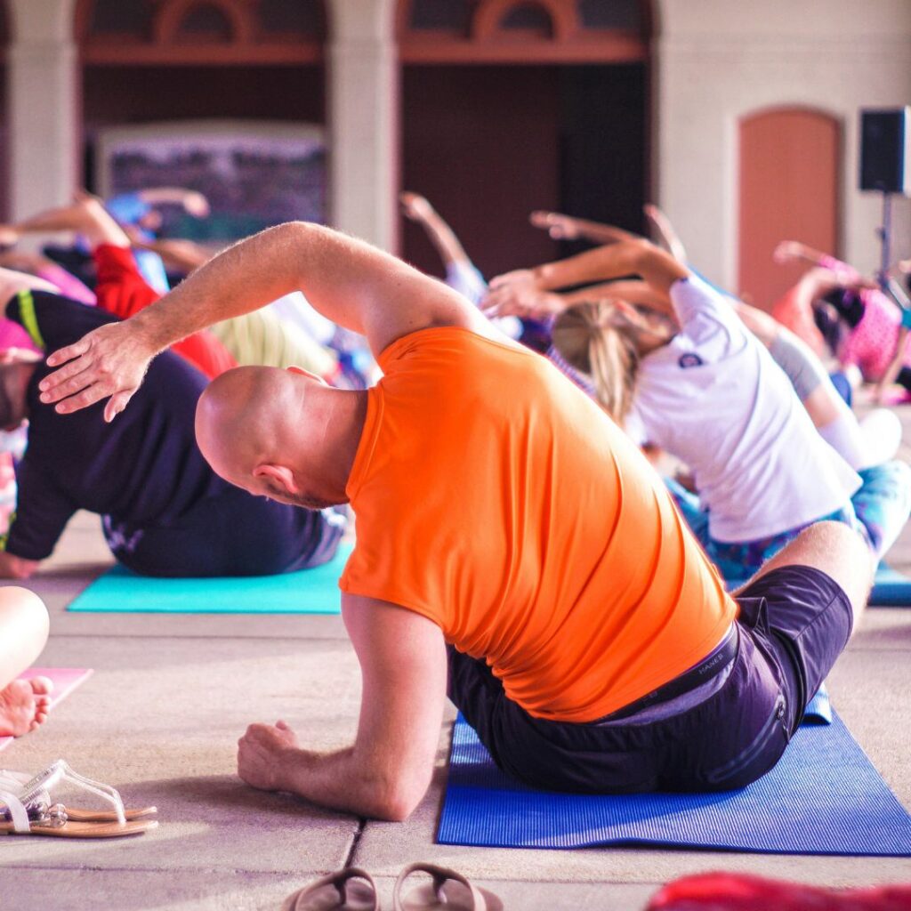 People in yoga class stretching.
