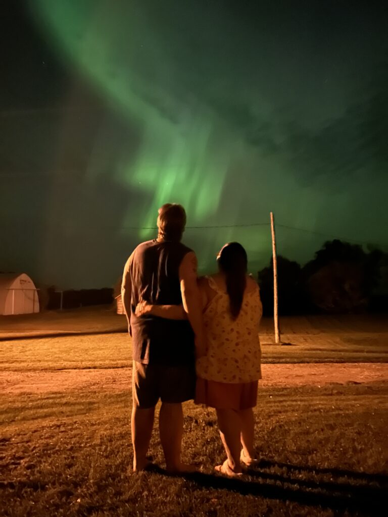 A couple looking out at aurora borealis