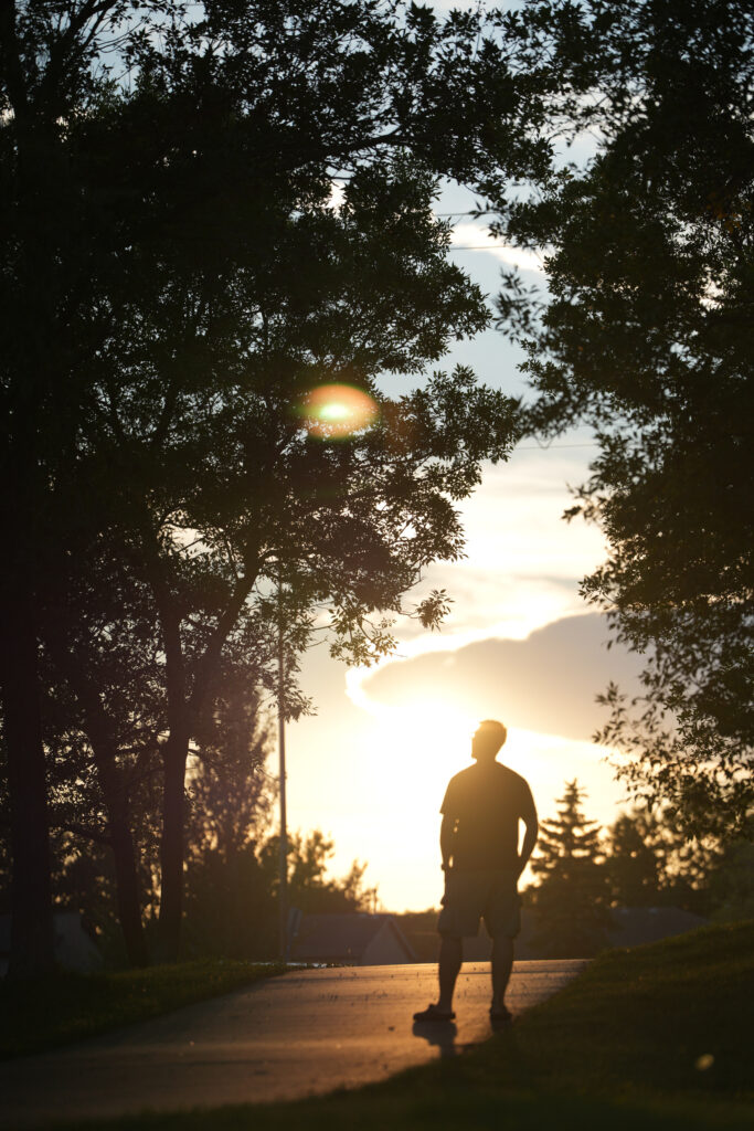 A man and the sunrise on a wooded trail