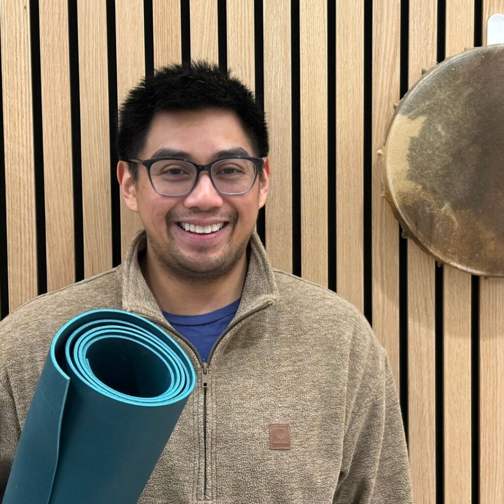 Yoga instructor Philip's photo holding a mat.