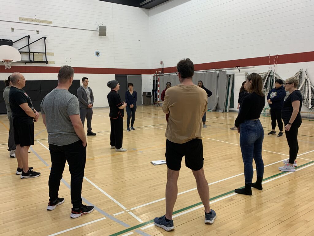 A group of college staff and students learning self defense.