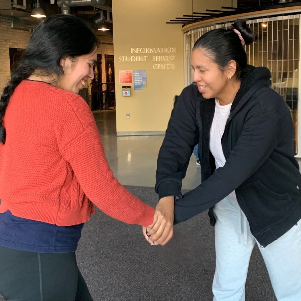 Two college students practicing a grip release self-defense move. 