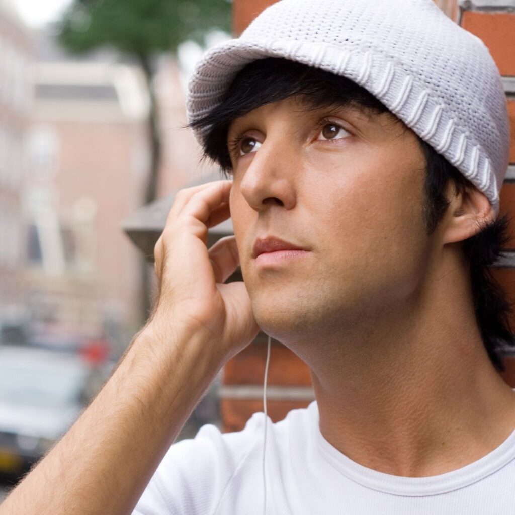 Young man listening to music and humming.