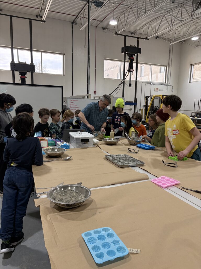 Engineering instructor, David Poole demonstrating how to mix concrete with the campers