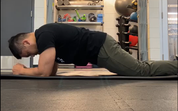Henry demonstrating a forearm plank on the knees.