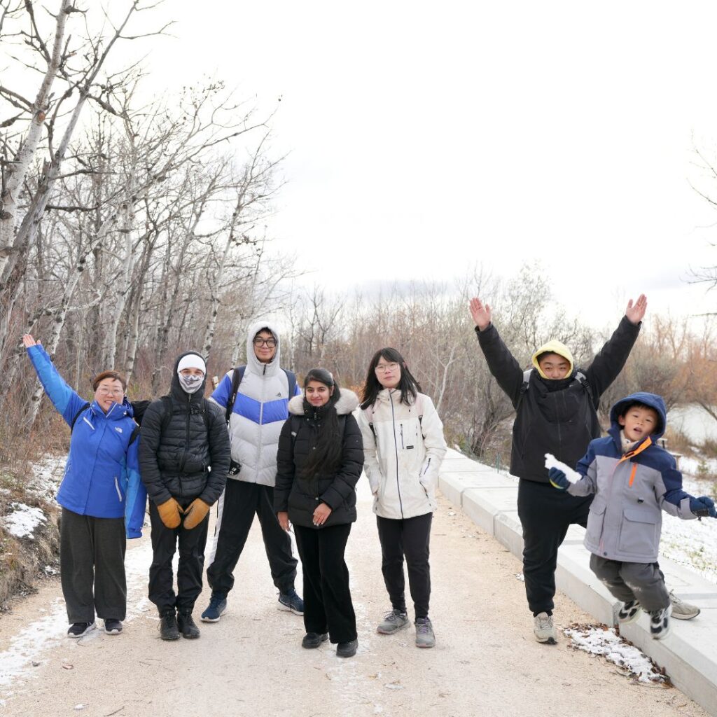 Group of people with arms up outside enjoying a hike.
