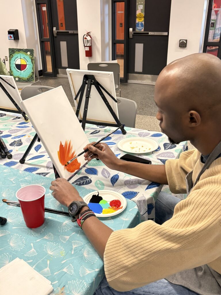 Student starting to paint on a canvas.