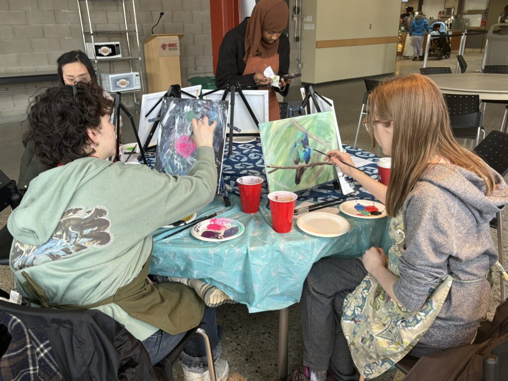 Four students at a table painting