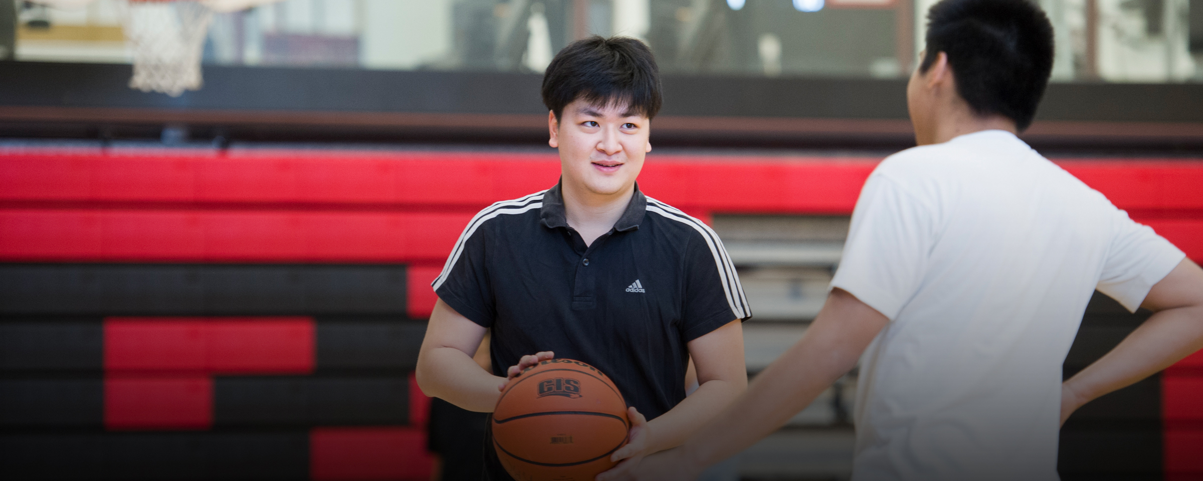 Two men playing basketball in gym