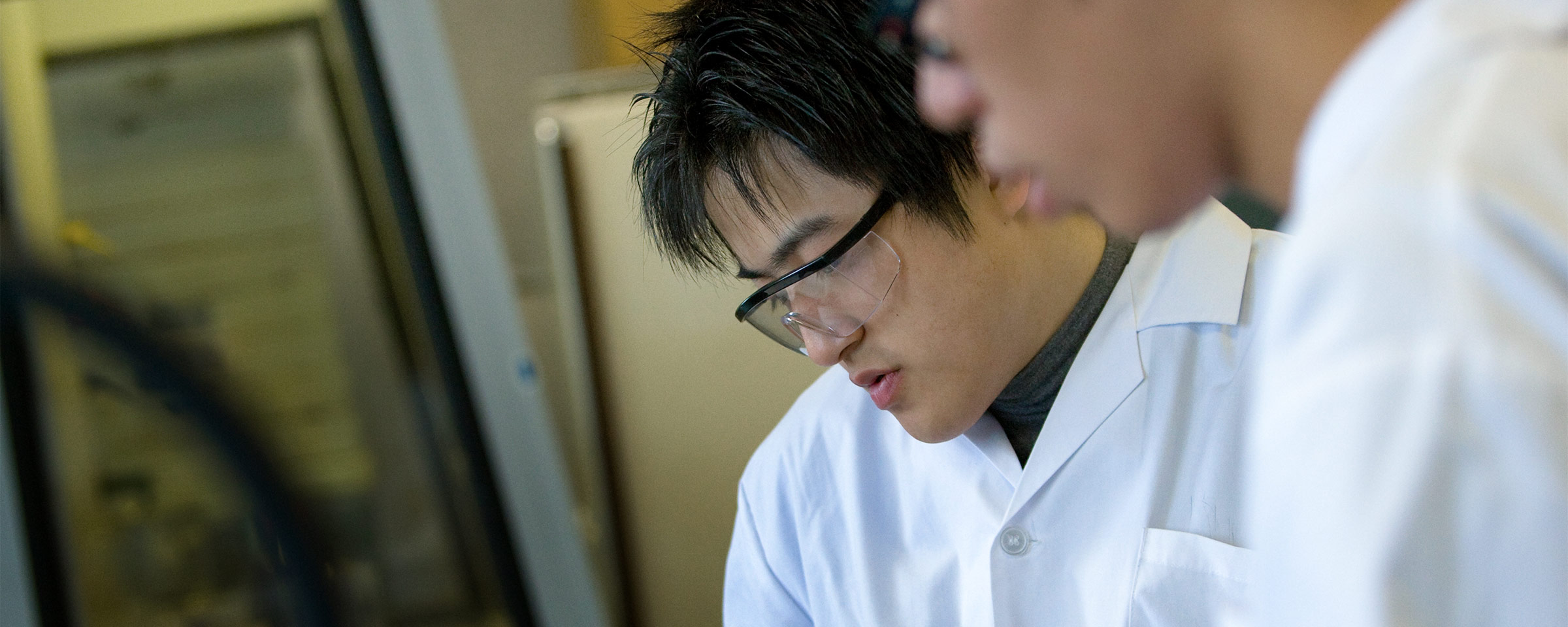 Two male students working in lab coats