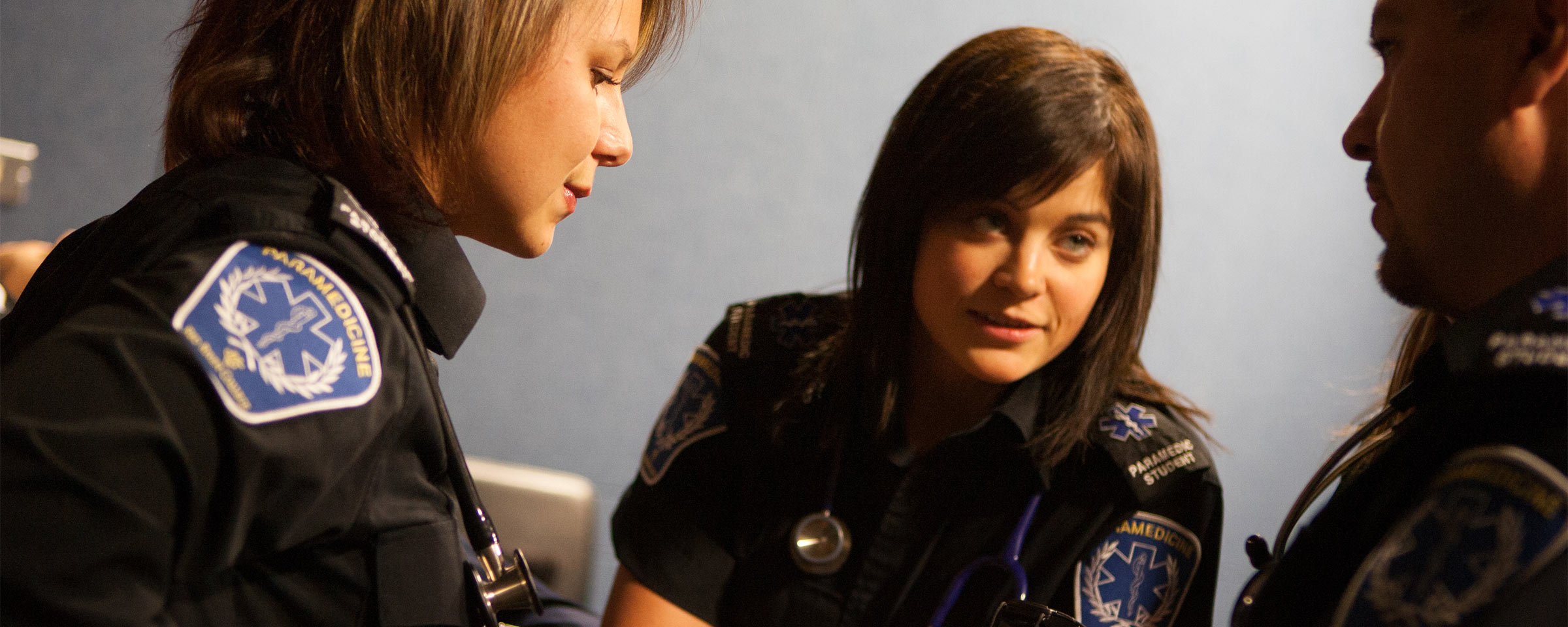 Two female paramedics assisting a male patient