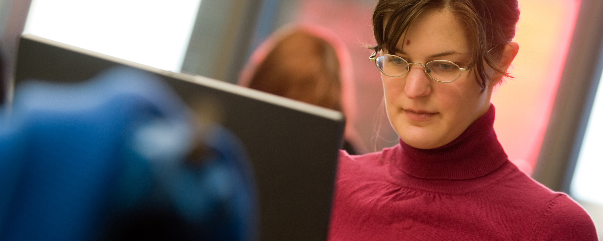 Woman with glasses working on computer
