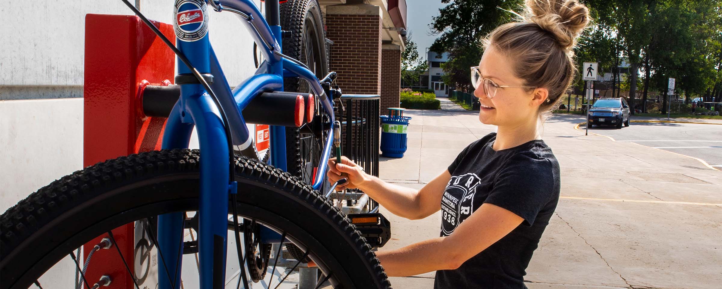 Woman adjusting bolt on bicycle.