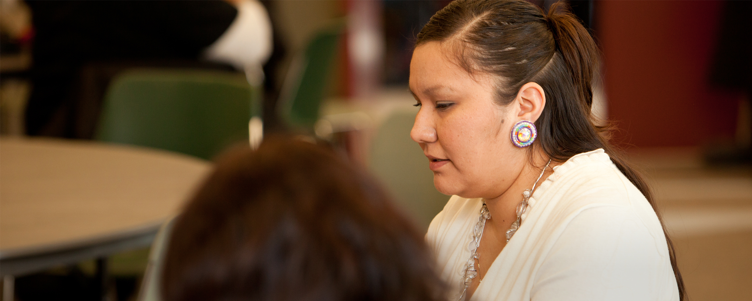 Side profile of Indigenous woman sitting with others in a classroom