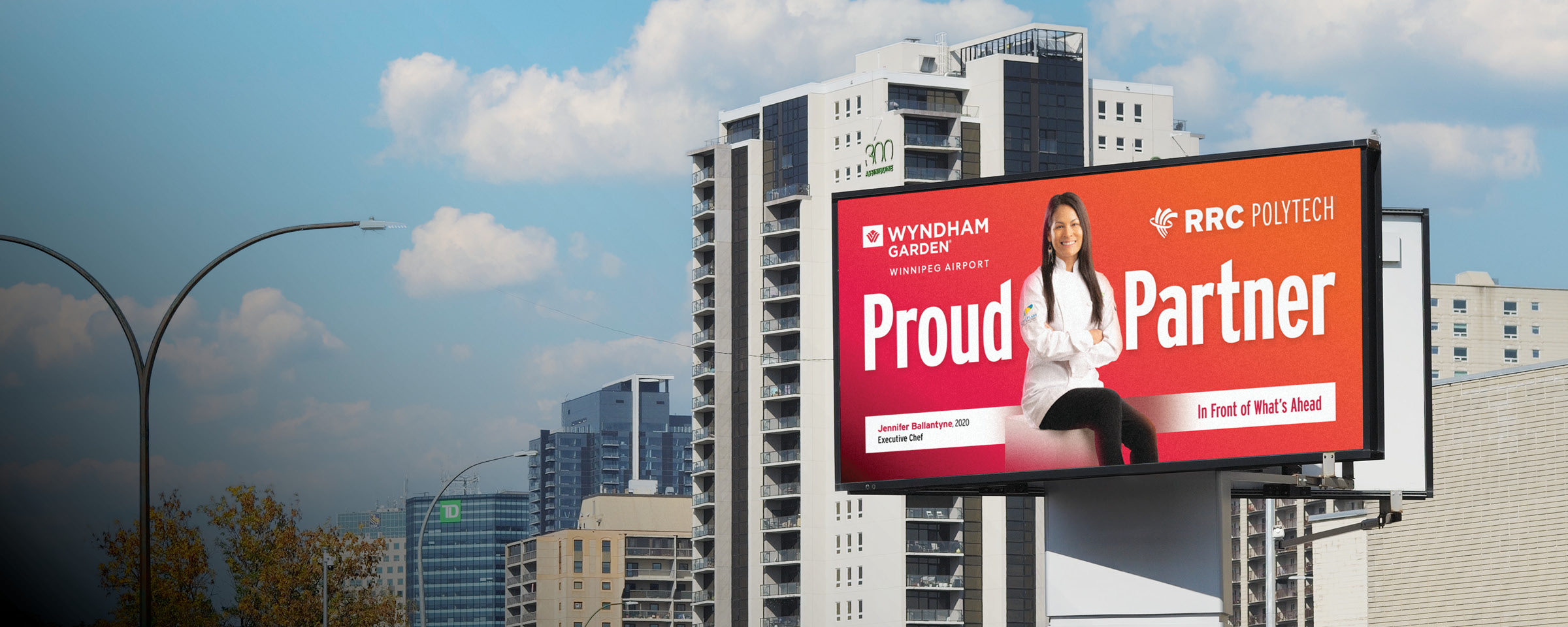 Winnipeg skyline with "Proud Partner" billboard of RRC Polytech graduate Jennifer Ballantyne.