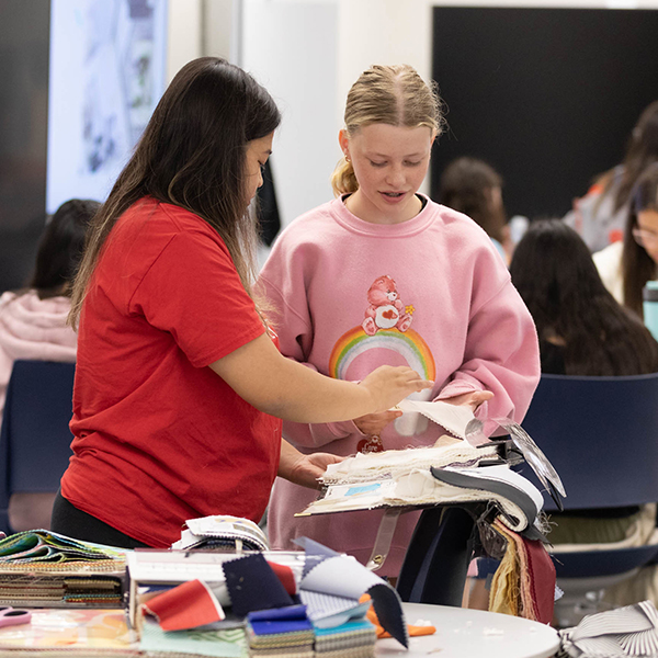 two girls looking at textiles