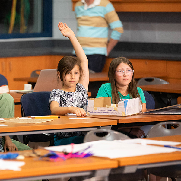 two girls, one has her hand up